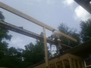 Carpenter setting a ridge beam over a new addition frame — Ice Dam Removal by Roofing Brothers in Mill Creek